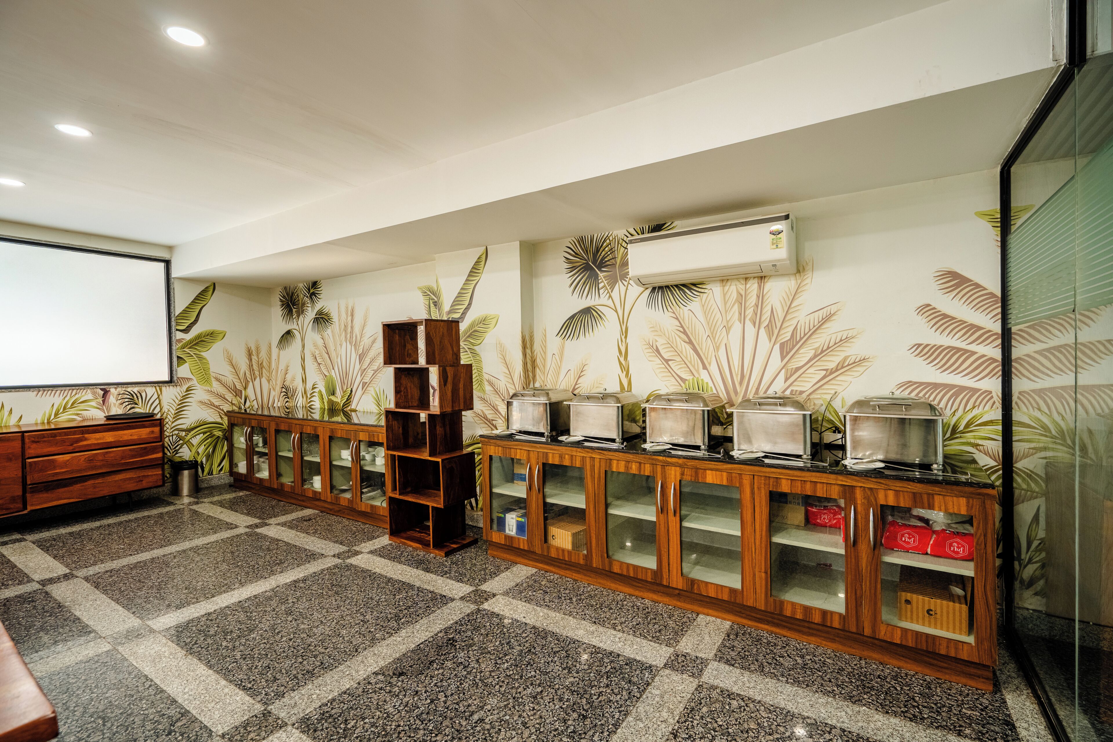 A room with a checkered floor, wooden cabinets with glass doors, a projector screen, and wall-mounted air conditioning.