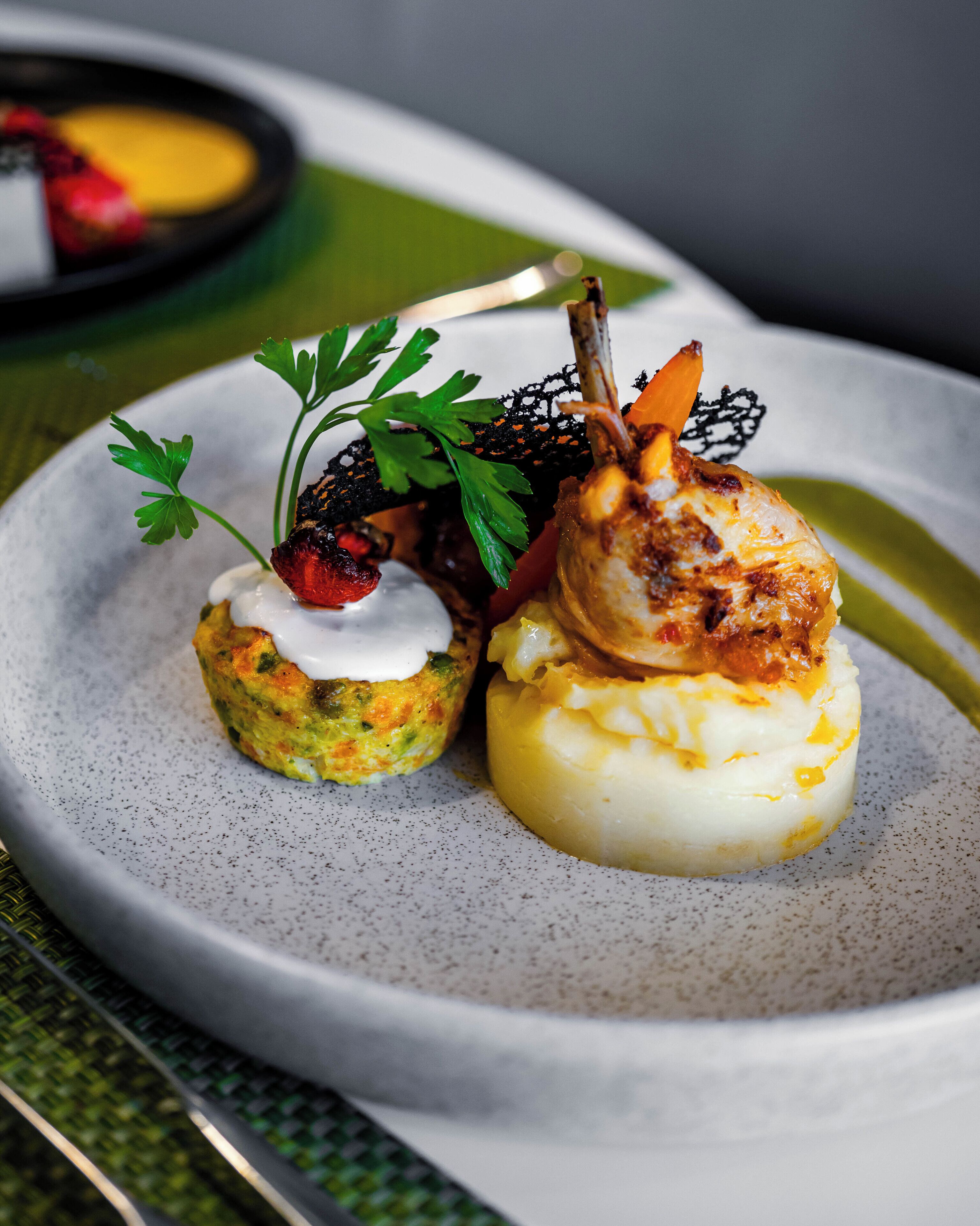 A plate with three different food items, garnished with parsley and a decorative element.