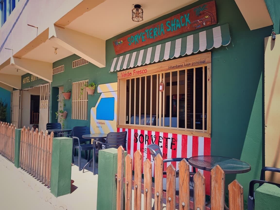 Um restaurante chamado 'Sorveteria Shack' com mesas ao ar livre e um cercado de madeira.