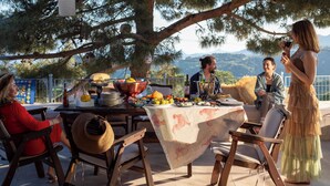 An outdoor dining area with a table set for a meal, surrounded by trees and a scenic view. - Mila House (Ayvacik)