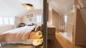 A bedroom with a large bed, bedside table, and a hanging light fixture.