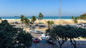 Ein Parkplatz am Strand mit Autos, Palmen und Blick auf den Ozean.