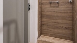 Een moderne kamer met een grijze schuifdeur en een houten deur met een handvat.