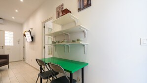 A compact kitchen with a green countertop, two chairs, and white shelves. - M Sfu71 Acogedor Piso con Terraza y Espacios par (Madrid)