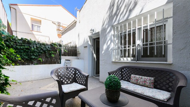 An outdoor seating area with wicker furniture and a potted plant. - M Sfu71 Acogedor Piso con Terraza y Espacios par (Madrid)