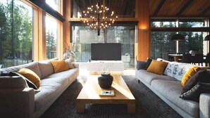 A modern living room with two sofas, a coffee table, and a large window.