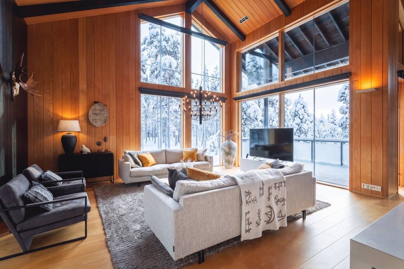 A spacious living room with a large sofa, a television, and a fireplace.