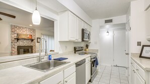 A modern kitchen with white cabinetry, a stainless steel sink, a microwave, and a dishwasher.