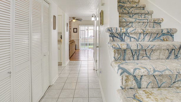 A staircase with patterned carpet leading to a landing.