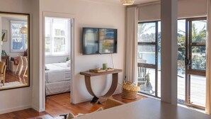 Une chambre d’hôtel avec un lit, une télévision, une petite table et une vue sur l’extérieur.
