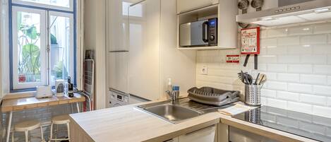 A modern kitchen with a built-in microwave, stainless steel sink, and a Bosch oven.