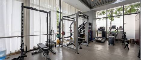 A gym with weightlifting equipment, treadmills, and benches.