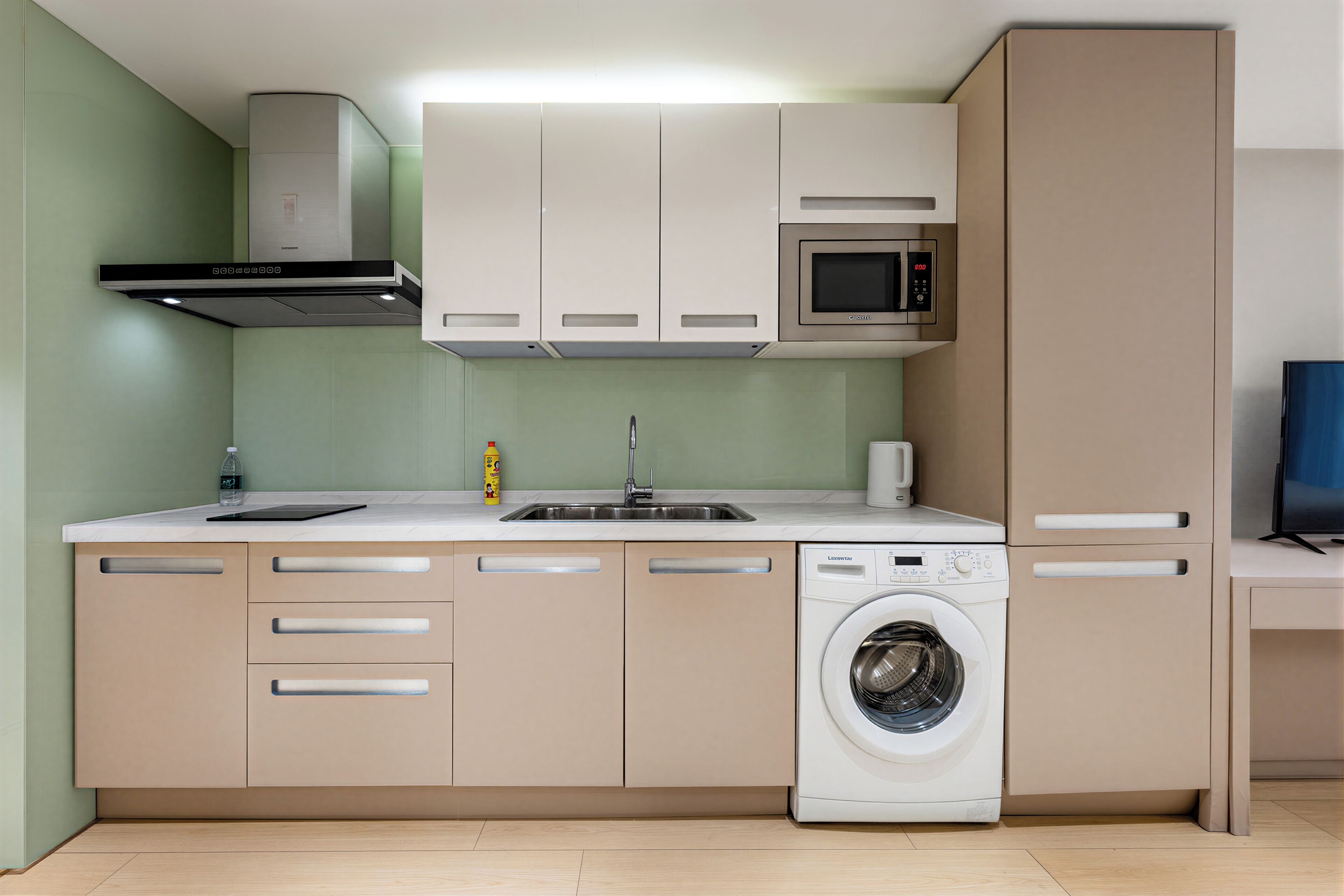 Una cocina compacta equipada con lavadora, microondas y lavabo.