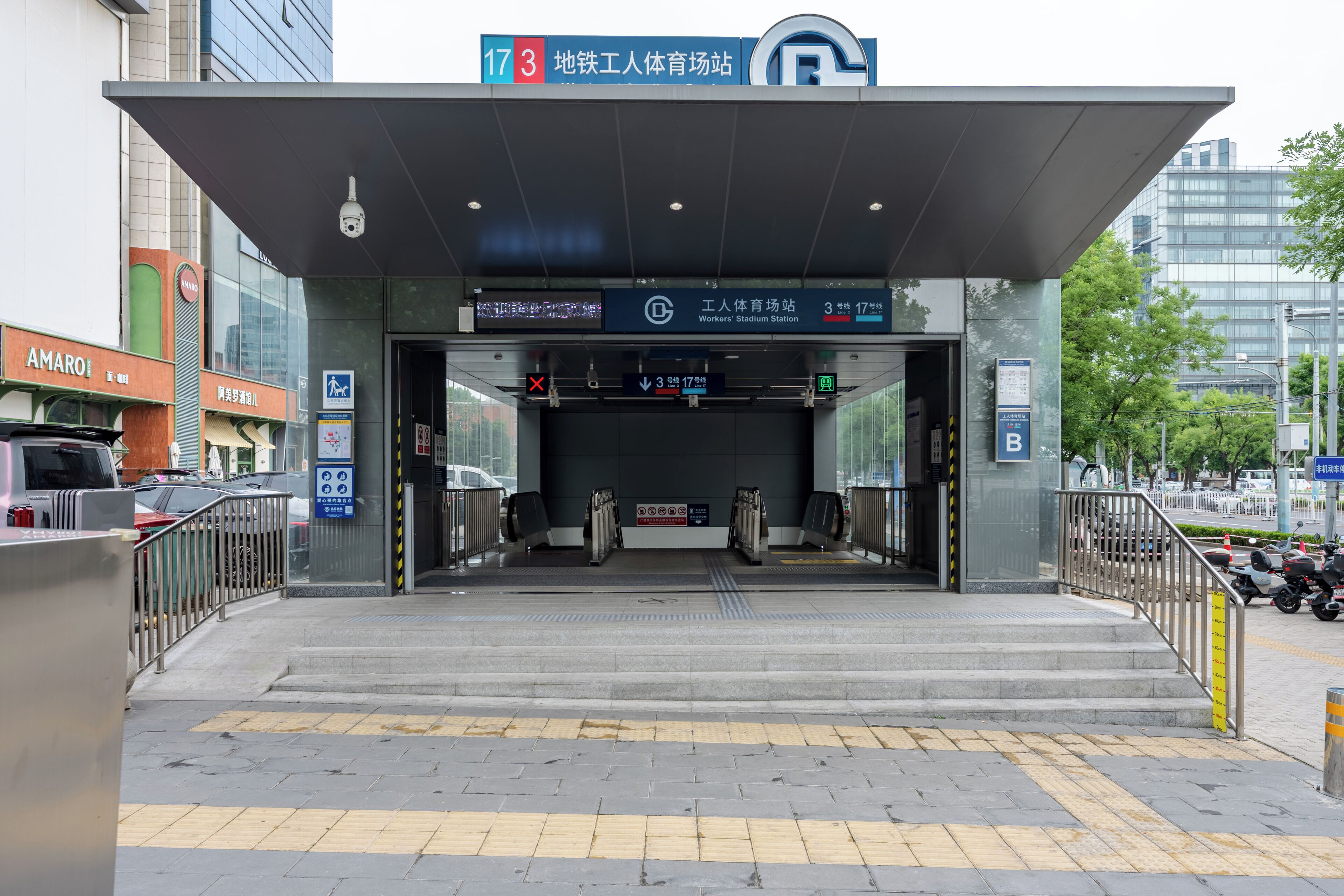 A building entrance with a ramp, signage, and a pedestrian crossing.