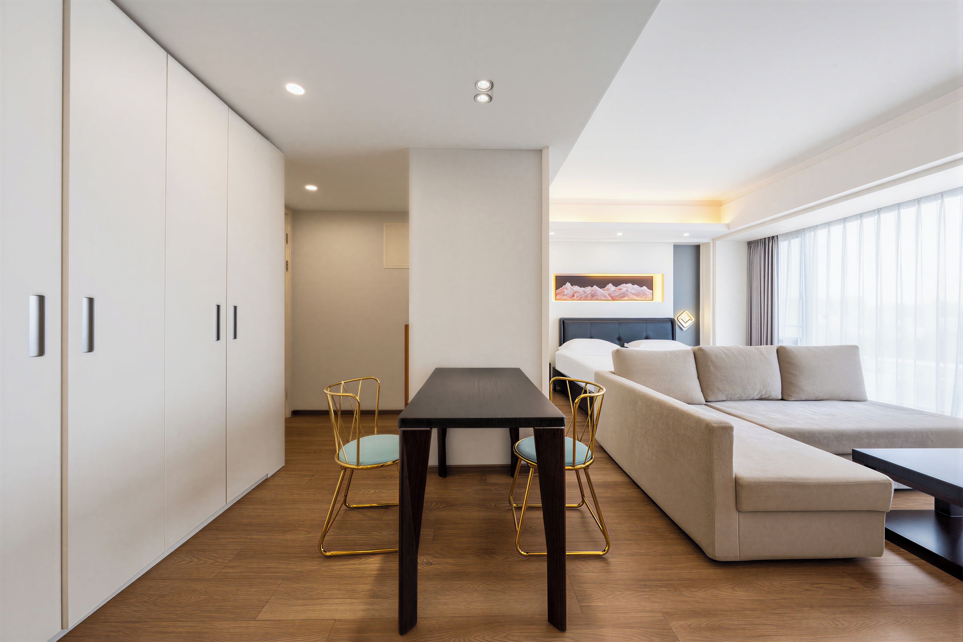 Un hotel moderno con sofá, una mesa de comedor y vistas a la ciudad.