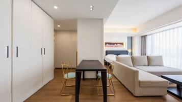 Un hotel moderno con sofá, una mesa de comedor y vistas a la ciudad.