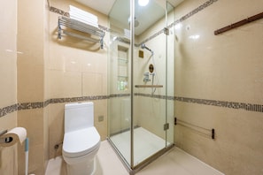 A bathroom with a toilet, a glass-enclosed shower, and a towel rack.