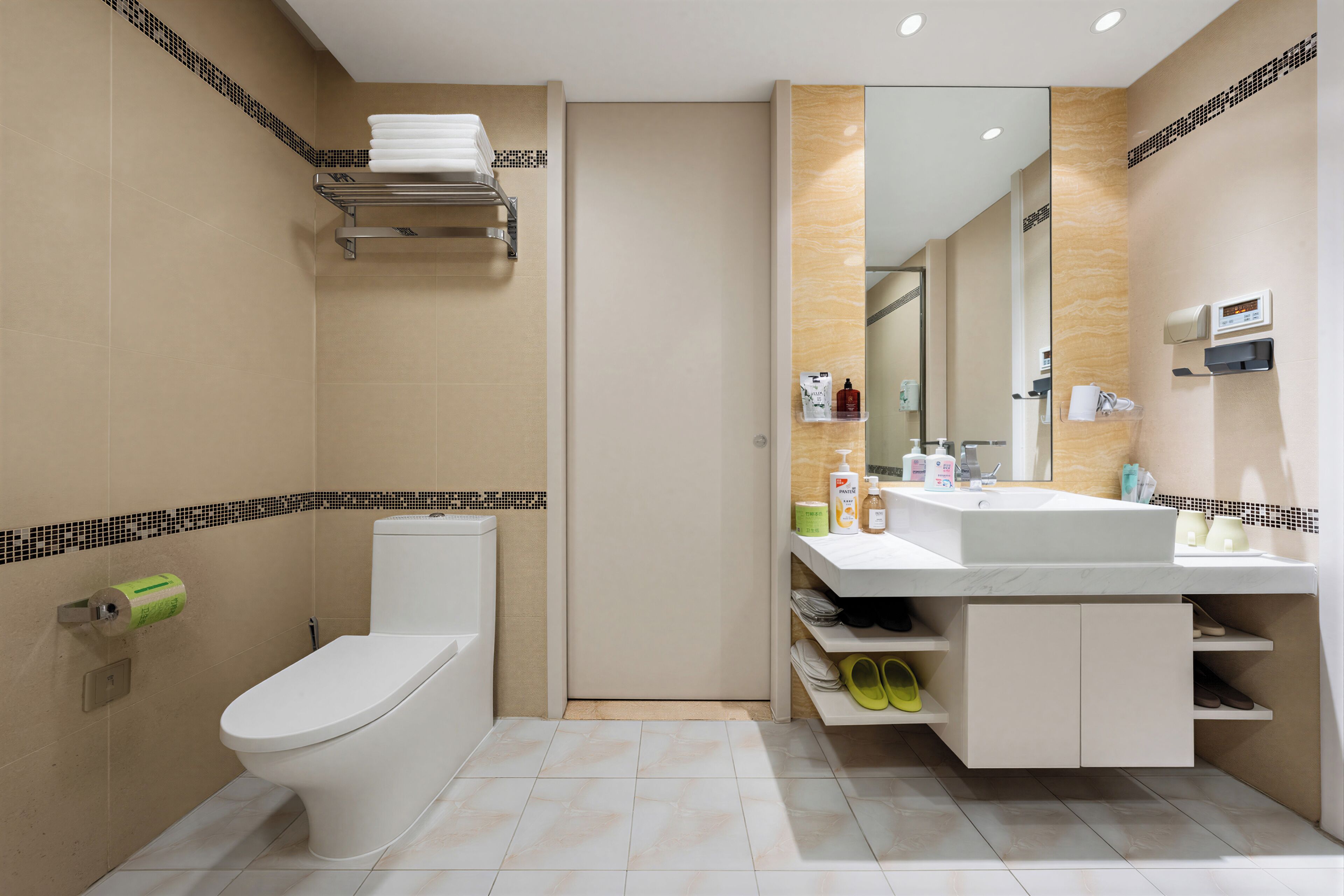 Een moderne badkamer met toilet, wastafel en spiegel.