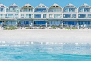 Un hôtel situé en bord de mer, avec plusieurs étages, des balcons et une vue dégagée sur l’océan.