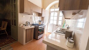 Une cuisine avec des meubles de rangement en bois, une cuisinière, un évier et une fenêtre.