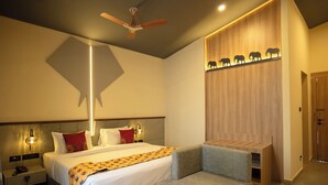 Ein modernes Hotelzimmer mit einem Bett, Nachttischen, einem Schreibtisch, einem Deckenventilator und einem Wandregal mit Tierkonturen.
