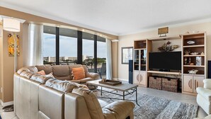 Una sala de estar moderna con un sofá, una mesa de centro, televisor y mueble de entretenimiento.