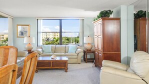 A living room with a sofa set, wooden coffee table, and a large wooden cabinet.