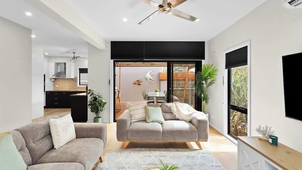 A modern living room with a sofa, a coffee table, and a ceiling fan. - Stylish Townhouse 2 Min Walk to Beach & Shops (Cowes)