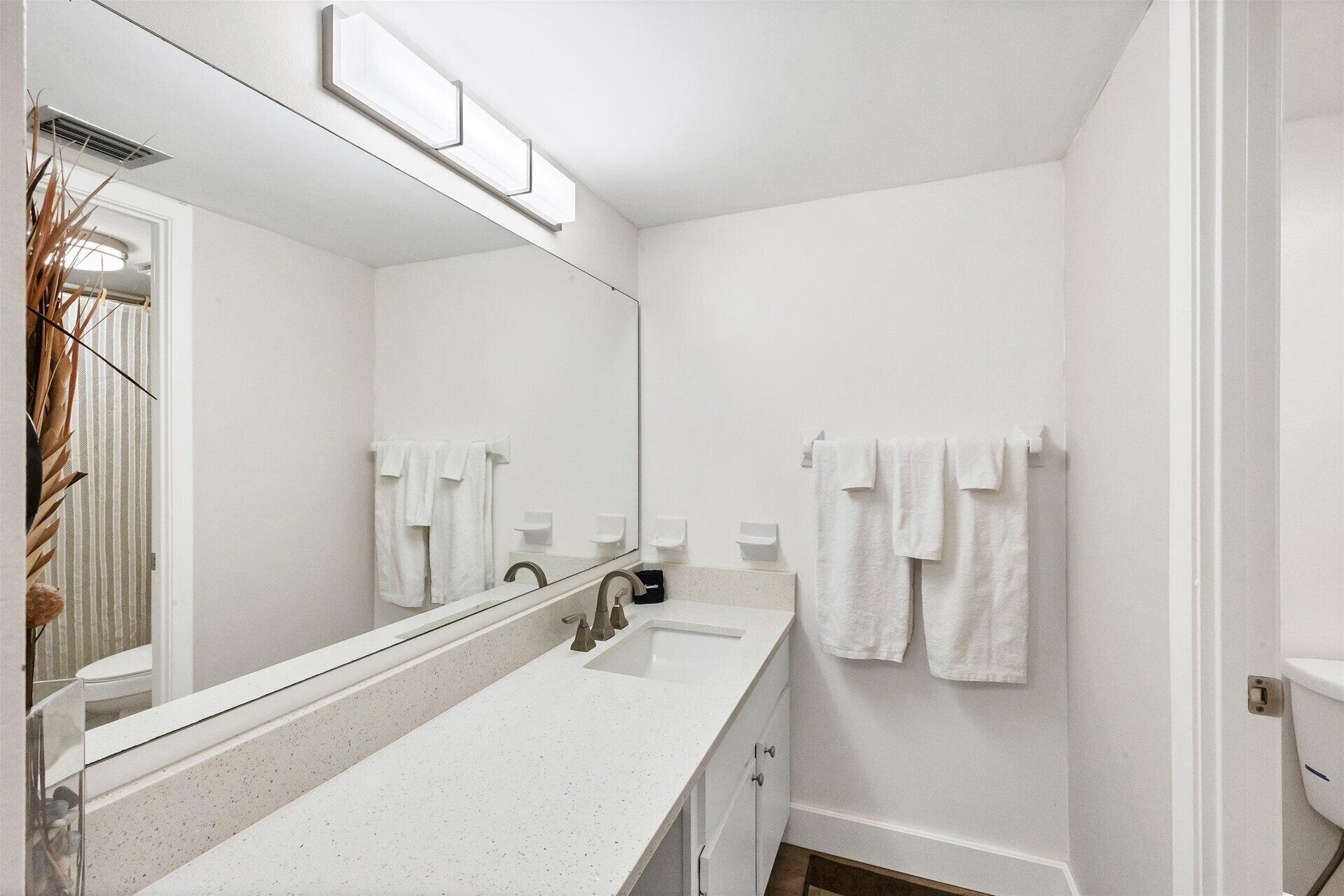 Un bagno moderno con lavandino, specchio e portasciuga in bianco.