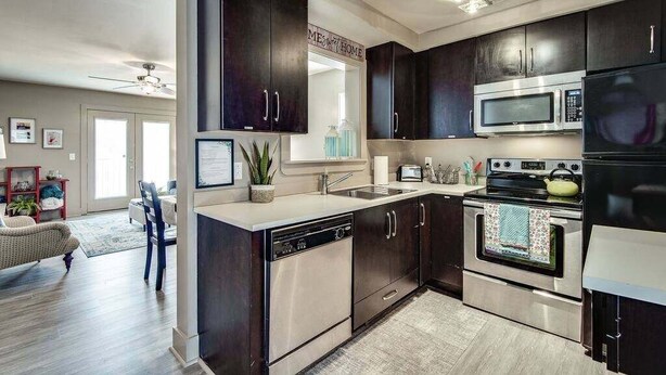 A modern kitchen with dark cabinets, stainless steel appliances, and a dishwasher. - Loft #211 (540 N 2nd St) (Clarksville)