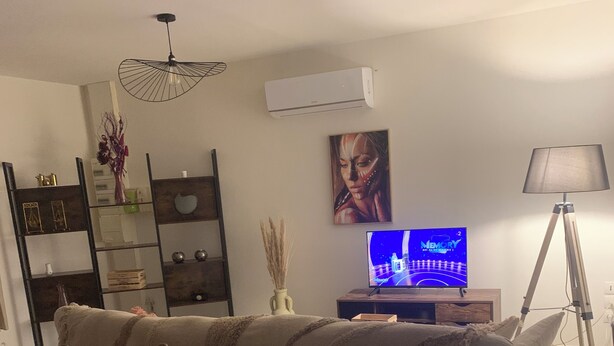 A living room with a sofa, a TV displaying 'MEMORY', a lamp, and a bookshelf. - Apartment in the countryside 30mn from the 24h of Le Mans (Saint-Georges-du-Rosay)