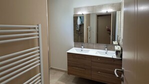 A modern bathroom with a double sink vanity, a towel rack, and a mirror. - Bright, quiet house in Redessan (Redessan)