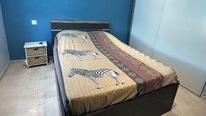 A bedroom with a bed, a nightstand, and a wardrobe. - Bright, quiet house in Redessan (Redessan)