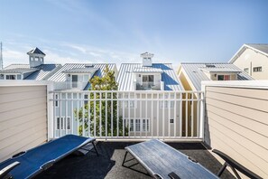 A rooftop terrace with a metal roof, white railings, and a view of neighboring buildings. - Sunset Island 43 Sunset Island Drive (Ocean City)