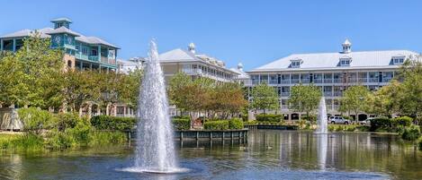 A fountain in a courtyard with buildings in the background.