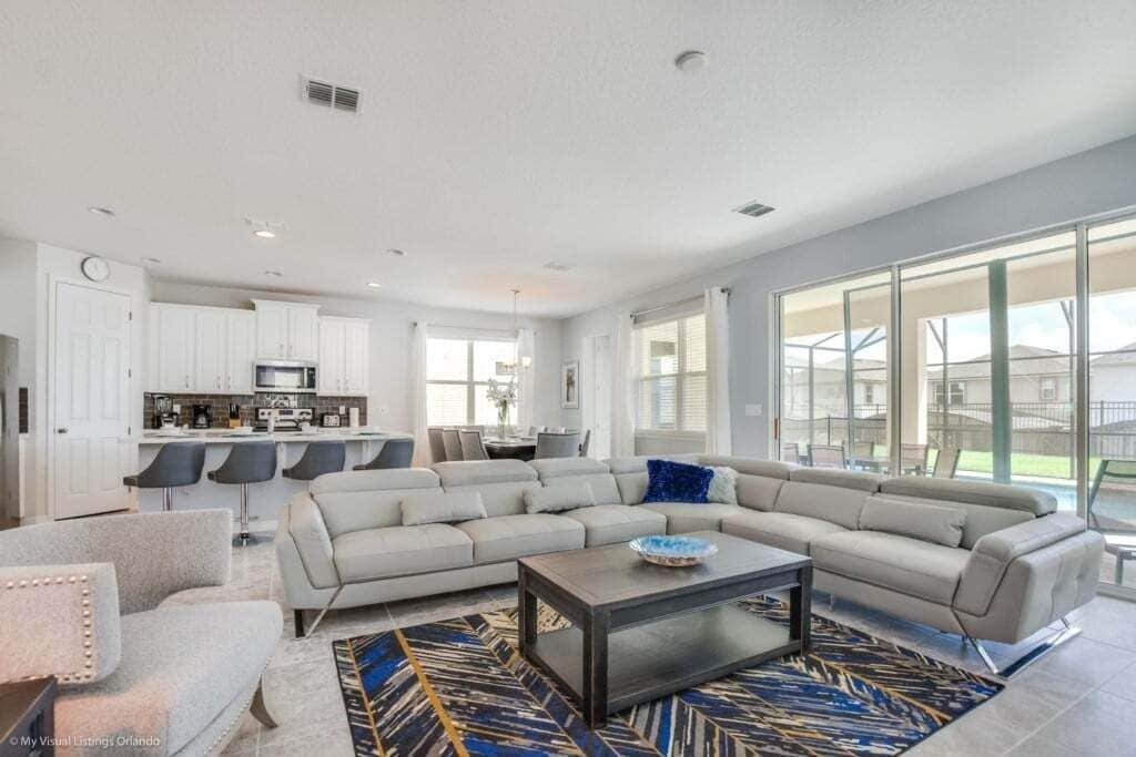 A modern living room with a sectional sofa, a coffee table, and a patterned rug.
