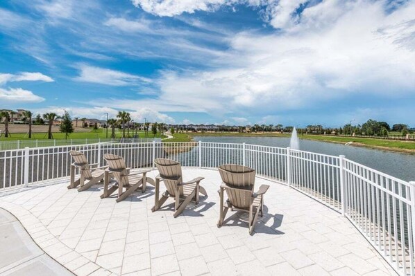 Un patio frente al río con mesas al aire libre y vistas.