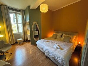 A hotel room with a bed, bedside table, chair, and a window with curtains. - Le Cozy (Saint-Jean-Poutge)