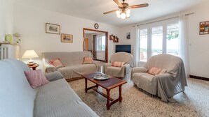 A living room with a sofa, armchairs, a coffee table, a ceiling fan, and a large window. - Gîte La Motette Drôme Provençale (Rousset les Vignes)