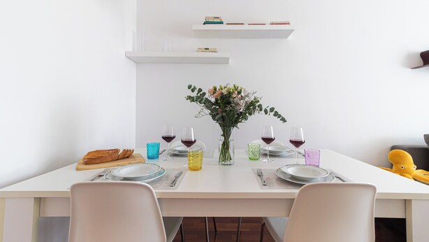 A dining table set with plates, glasses, and a vase of flowers. - Italianway Easy - Papiniano 38 (Milan)