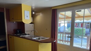 A compact kitchen with a built-in stove, sink, and a refrigerator.