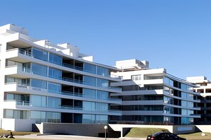 A multi-story modern building with balconies, large windows, and a clear sky. - Oceana Suites Lumiere (Punta del Este)