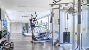 Een sportschool met loopbanden, krachttoestellen en gewichten.