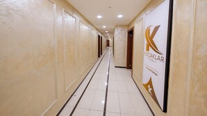 A hotel corridor with cream-colored walls, a tiled floor, and a sign for Kocaklar Hotel. - Koçaklar Otel (Karapınar)