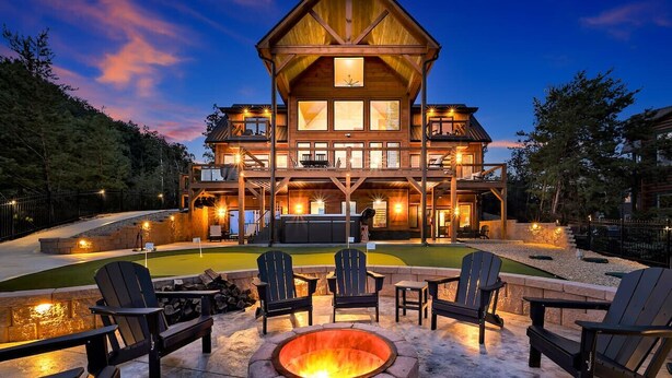 A large lodge with a fire pit and outdoor seating. - New! Loaded Luxe w/Pool*Theater*Game Room*Views! (Sevierville)