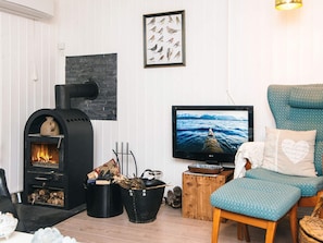 Una sala acogedora con chimenea, televisor y un espacio de estar confortable.