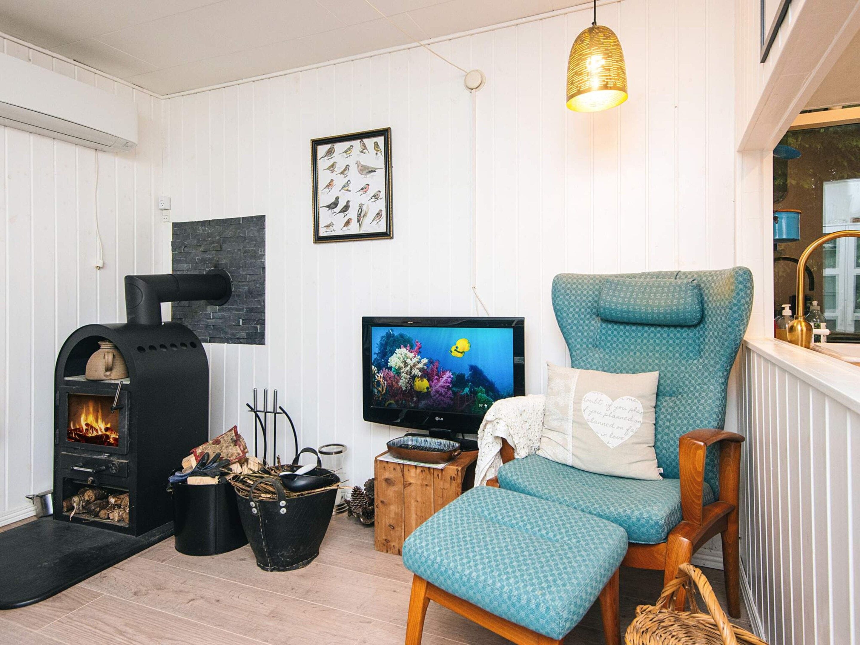 Ein gemütliches Wohnzimmer mit Kamin, Fernseher und einer bequemen Sitzecke.