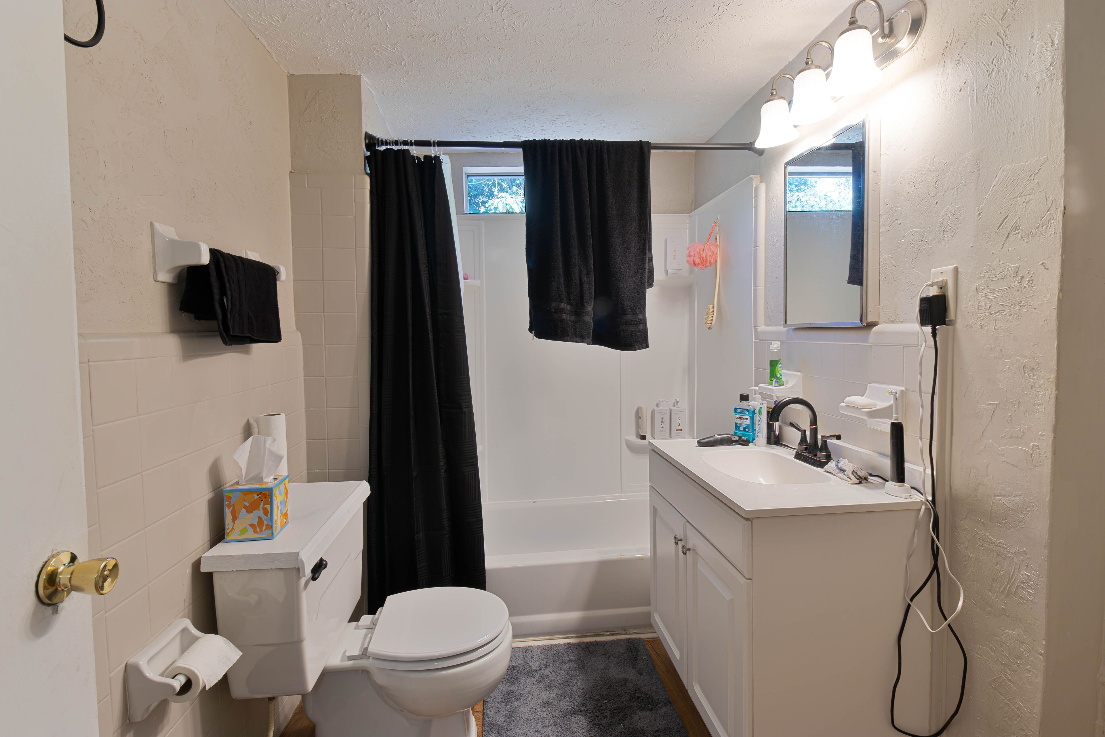 A bathroom with a toilet, sink, and bathtub.