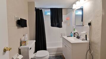 A bathroom with a toilet, sink, and bathtub.