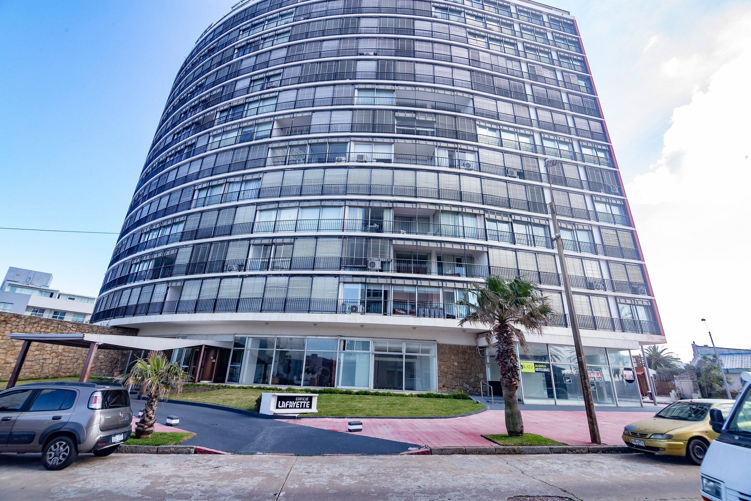 A modern multi-story building with a curved facade, large windows, and a sign indicating a business center.
